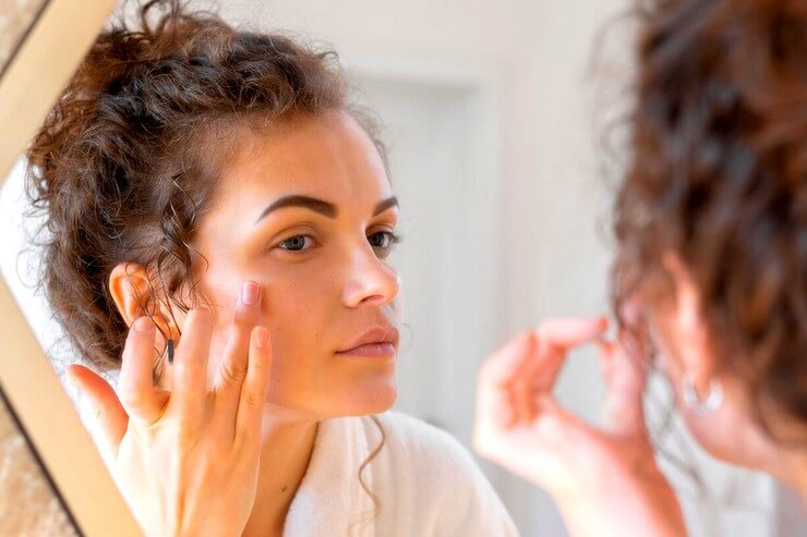 Femme vérifiant la peau de son visage