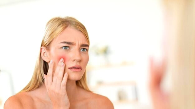 Femme vérifiant la peau sensible du visage