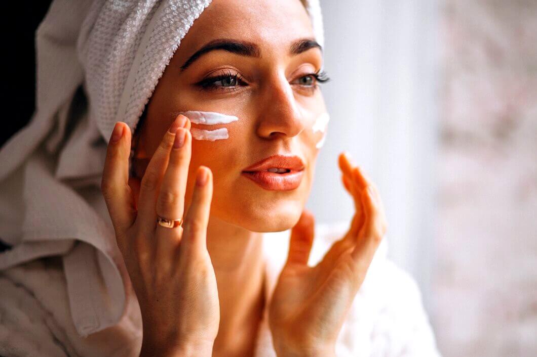 Jolie femme appliquant une crème pour visage