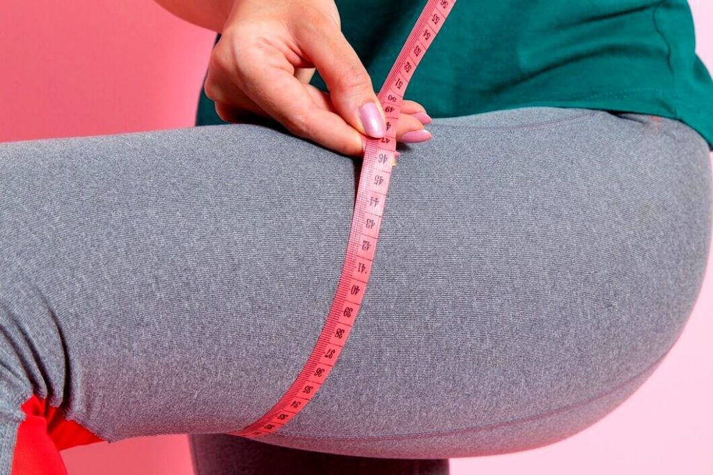 Femme mesurant la taille de sa cuisse