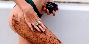 Femme applique du gommage sur sa cuisse