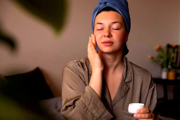 Femme appliquant une crème au visage