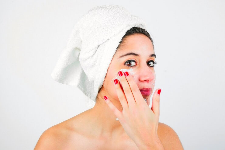 Femme applique une crème sur le visage
