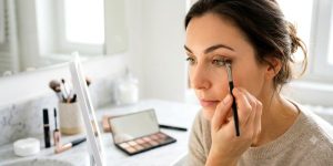 Jeune femme qui se maquille les yeux
